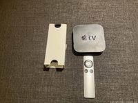 Apple TV unit, aluminum remote, white internal box insert