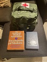 Closed olive drab medical bag with two textbooks