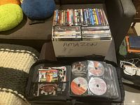 Box of DVD cases and zip binder with sleeved discs
