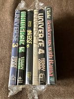 Six hardcovers standing showing spines and mylar-wrapped dust jackets