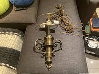 Full view of brass chandelier with wiring