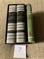Two cloth volumes in slipcase next to separate volume with dust jacket
