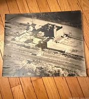 Full view of unframed aerial photo on wood floor