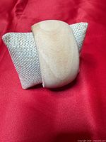 Front angled view of the wood bangle on display pillow