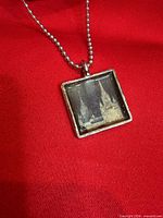 Front view of pendant on chain showing castle image in square bezel