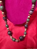 Full view of necklace draped on stand showing bead variety and length
