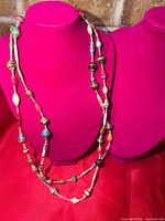 Full view of 48-inch multicolour paper bead necklace on display bust