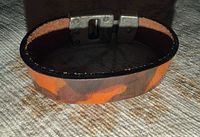 Top view of leather bracelet showing camouflage pattern and metal clasp