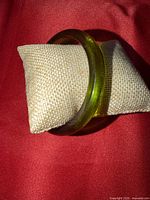 Bangle on small burlap pillow, showing translucent green color