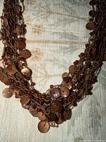 Close view of layered chains with brown discs and beads