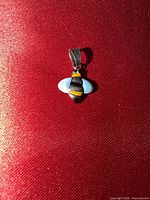 Front view of bee pendant on red background