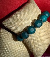 Bracelet side view on display cushion showing bead size and color