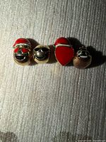Front view of all four goldtone emoji charms aligned horizontally