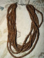 Full view of necklace showing multi strands of wooden beads and clasp
