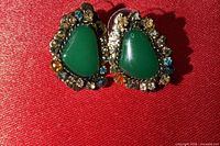 Front view of both earrings showing green cabochon centers and surrounding rhinestones