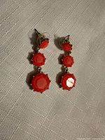 Pair of earrings on fabric background showing full length and setting