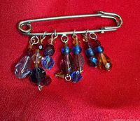 Front view of brooch showing silver pin and multicolour crystal dangles