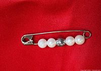 Full view of safety pin brooch showing bead arrangement