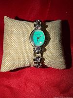 Front view of Rumours watch on pillow showing blue dial and bracelet