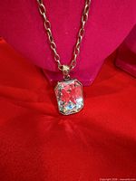 Close-up of pendant showing rectangular clear crystal in silver-tone frame