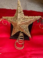Front view of 3-D gold wire glitter star with coiled base