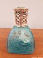 Full view of frosted blue swirl glass lamp with diffuser crown