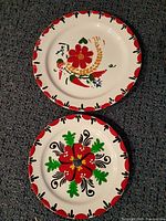 Both porcelain plates, showing size difference and folk floral designs