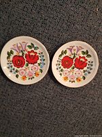 Both matching floral plates shown side by side