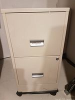 Front view showing two drawers, lock, and casters