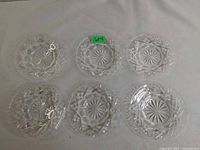 Six crystal side plates laid out on white surface