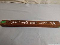 Front of wood bar sign displaying white text and graphics