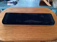 Closed black velvet jewellery travel case on tabletop