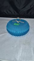 Lidded blue glass dish showing top view with metal handle