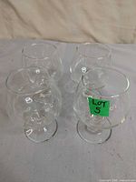 Four clear brandy glasses grouped together