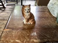 Front view of glazed ceramic cat figurine on table