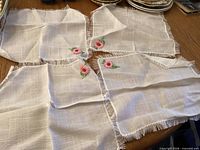 Full view of four embroidered napkins on table