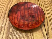 Top view of red enamel on copper plate showing abstract pattern