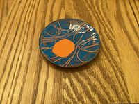 Front view showing blue enamel with orange abstract motif