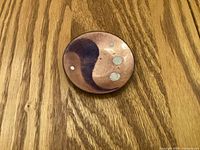 front of small enamel on copper plate showing purple motif on copper ground