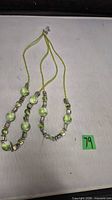 Full view of two-strand green glass and shell necklace