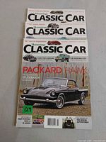 Three stacked Hemmings Classic Car magazines showing Packard Hawk cover and partial top issues