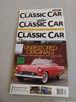 Three Hemmings Classic Car magazines stacked, showing August 2017 cover with red Ford Thunderbird