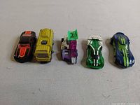 Five Hot Wheels cars lined up side by side showing various colours and styles