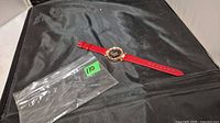 Front view of wristwatch next to empty plastic bag