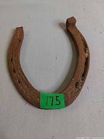 Front view of rusted iron horseshoe with nail holes visible