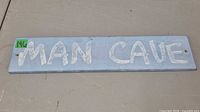 Front view showing full MAN CAVE text and mounting holes