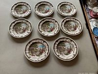 Top view of eight bread plates arranged in two rows showing front pattern and condition