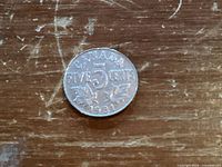 Reverse of 1931 Canadian 5-cent coin showing denomination, maple leaves and date