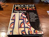 Front cover of Magic Motif Crochet book displaying title, author, project list and sample afghan image