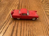 Left side view of red 1956 Ford Thunderbird diecast car